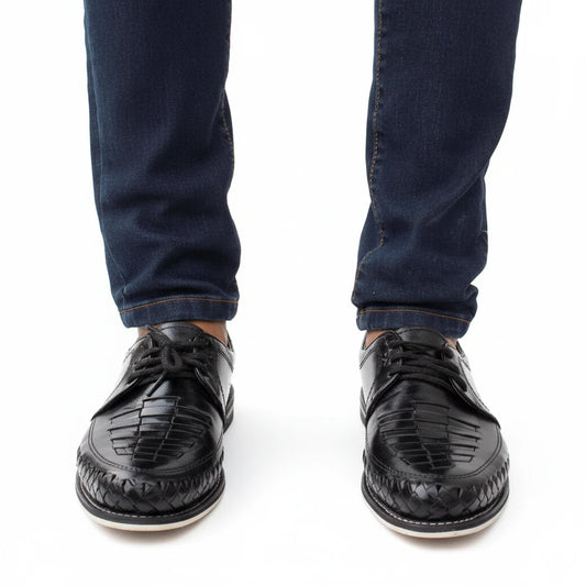 ARTESANALRENVAL black leather huarache shoes with woven detailing worn with dark blue jeans