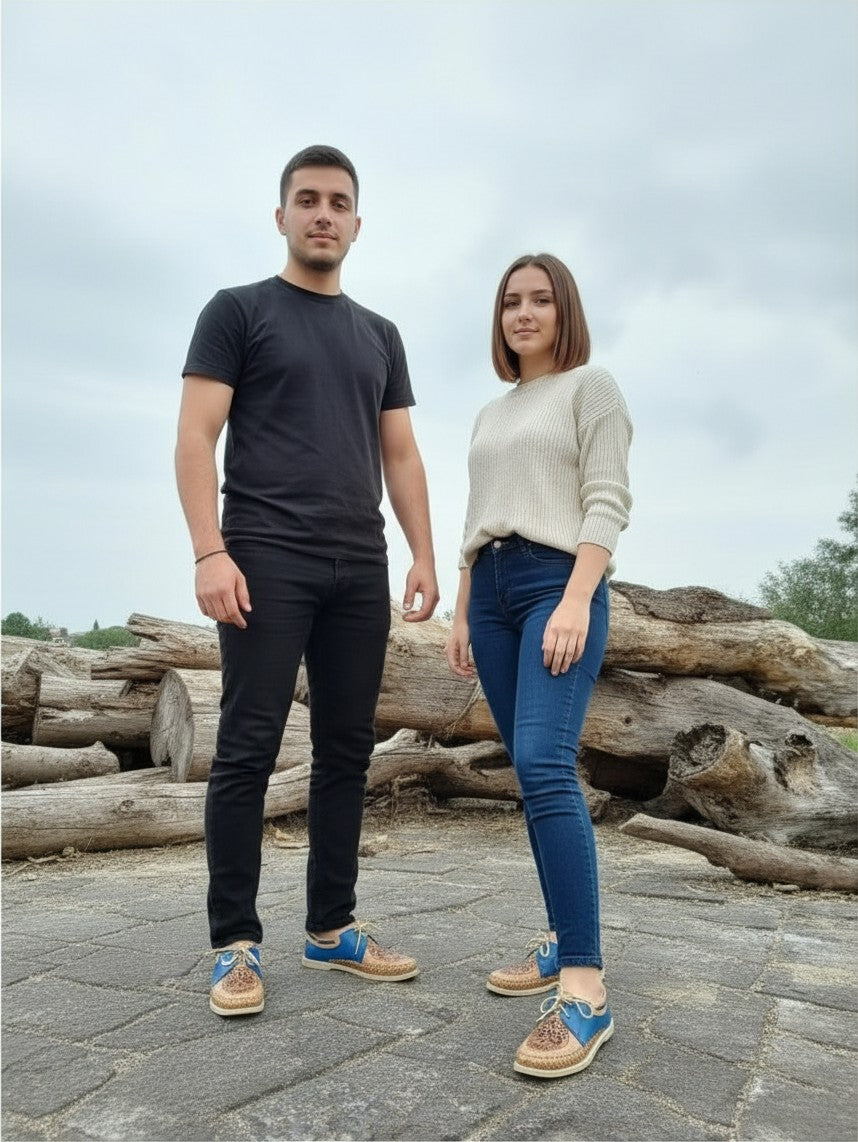 ARTESANALRENVAL handmade blue leather Catrina moccasins worn by a man and a woman standing outdoors on stone ground.