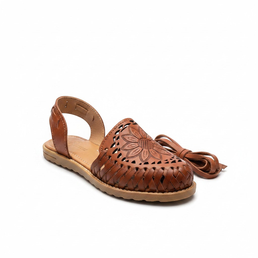 ARTESANALRENVAL brown leather huarache sandal with floral engraving and long ankle ties.