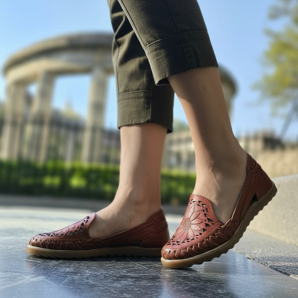 ARTESANALRENVAL brown leather huaraches with intricate floral cutouts and woven details. Women's artisan footwear.