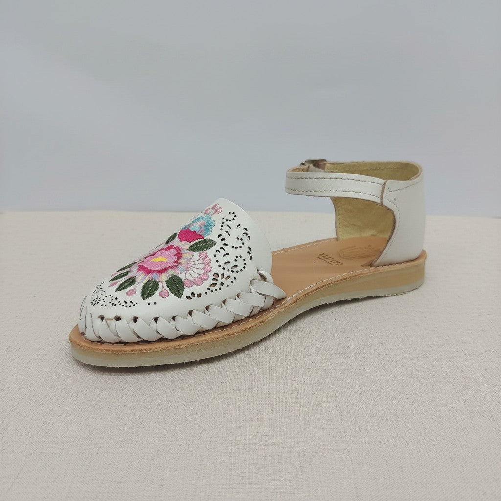 Huarache ARTESANALRENVAL blanco con bordado floral artesanal, suela flexible y correa al tobillo estilo bohemio.