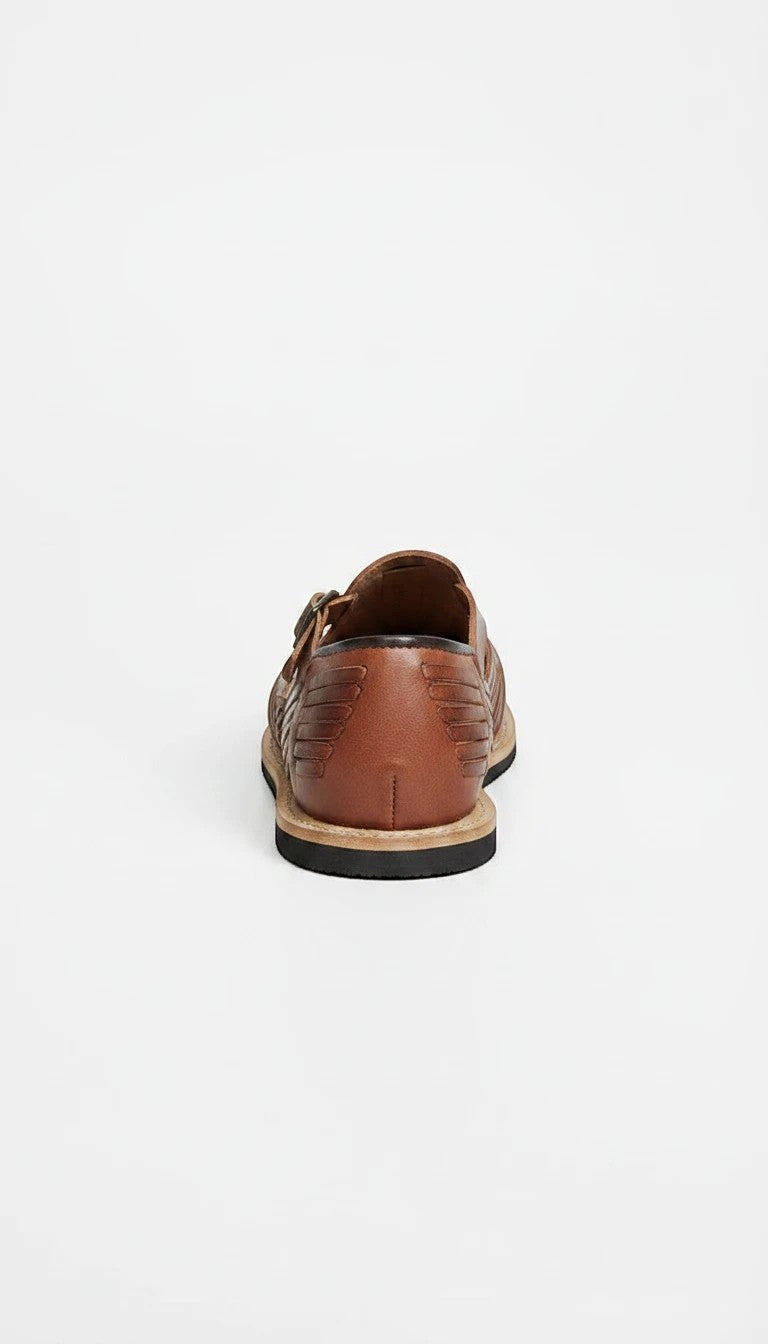Vista trasera de huarache ARTESANALRENVAL de piel color café con diseño trenzado y hebilla lateral ajustable