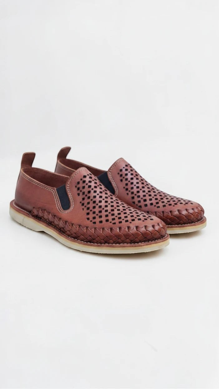 Mocasines ARTESANALRENVAL de piel marrón con diseño calado, trenzado perimetral y paneles elásticos laterales.