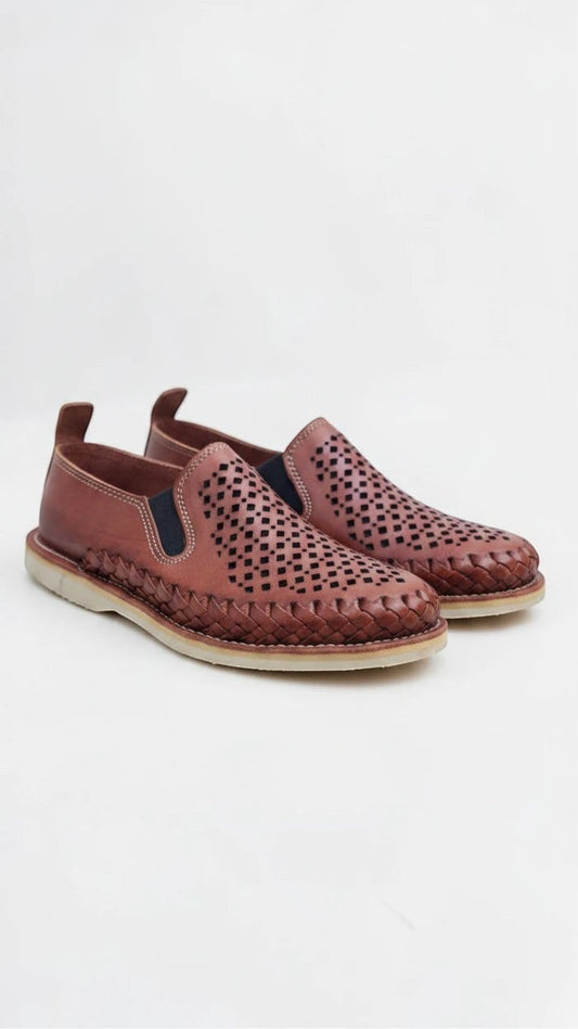 Mocasines ARTESANALRENVAL de piel marrón con diseño calado, trenzado perimetral y paneles elásticos laterales.