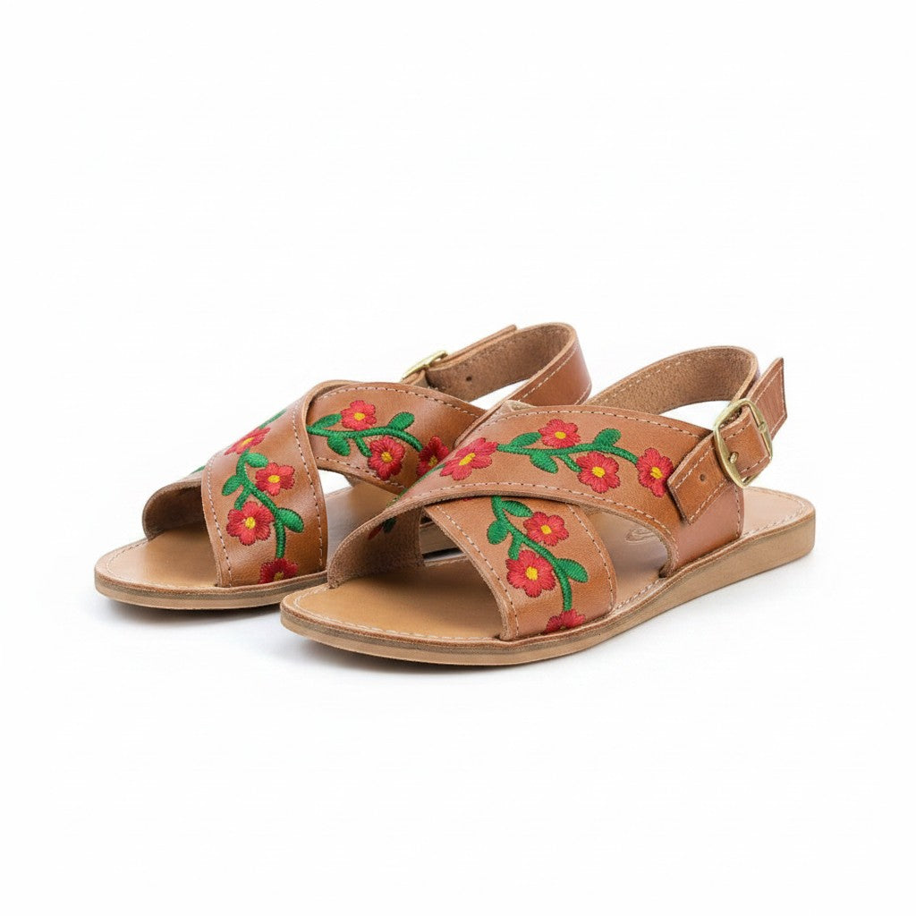 ARTESANALRENVAL tan leather huaraches with red floral embroidery and ankle strap with gold buckle.