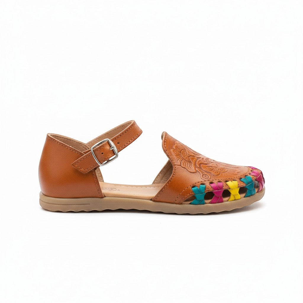 ARTESANALRENVAL tan leather huarache sandal with colorful woven accents and floral embossing. Adjustable ankle strap.