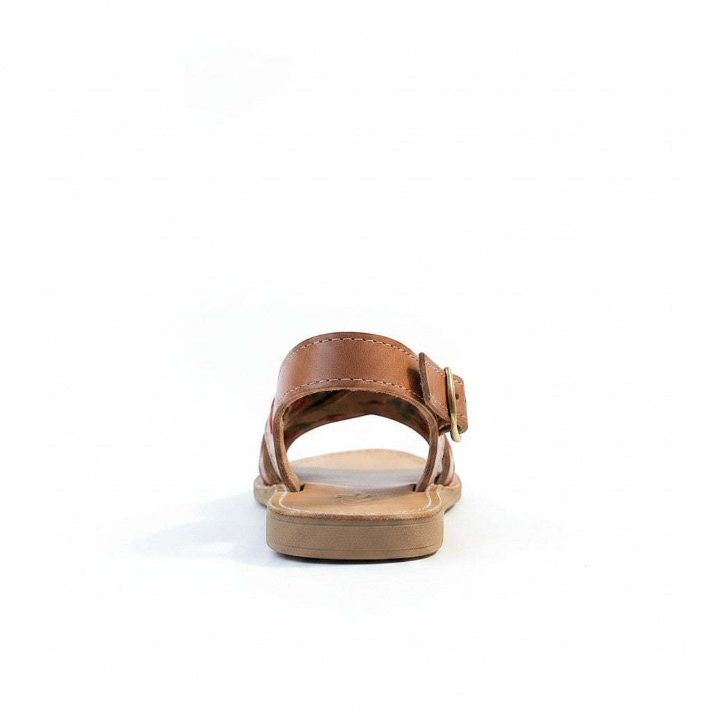 ARTESANALRENVAL tan leather huarache sandal with floral lining and gold buckle strap.