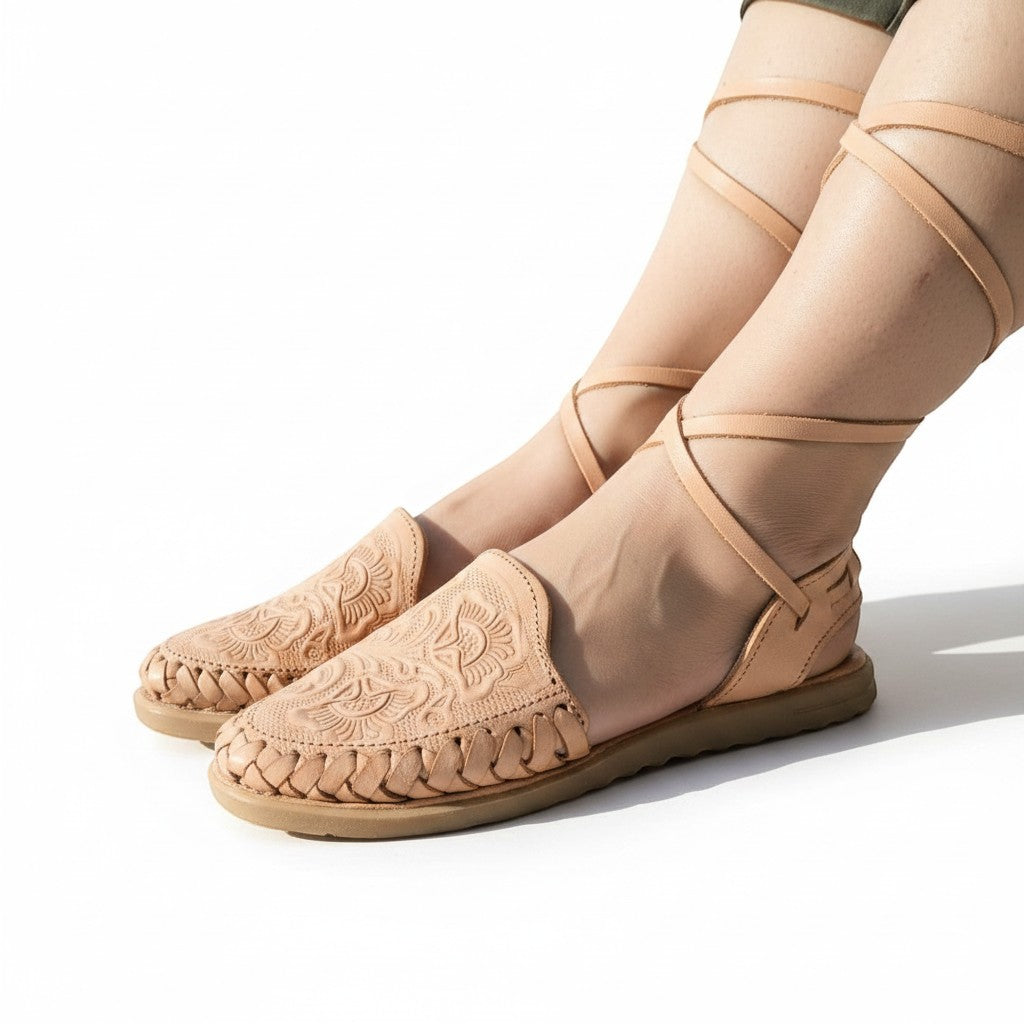 ARTESANALRENVAL natural tan leather huarache sandals with floral engraving and long ankle ties.