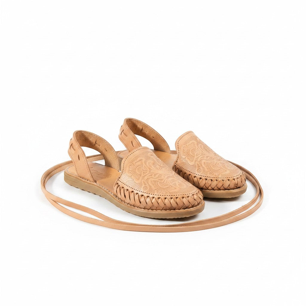 ARTESANALRENVAL natural tan leather huarache sandals with floral engraving and long ankle ties.