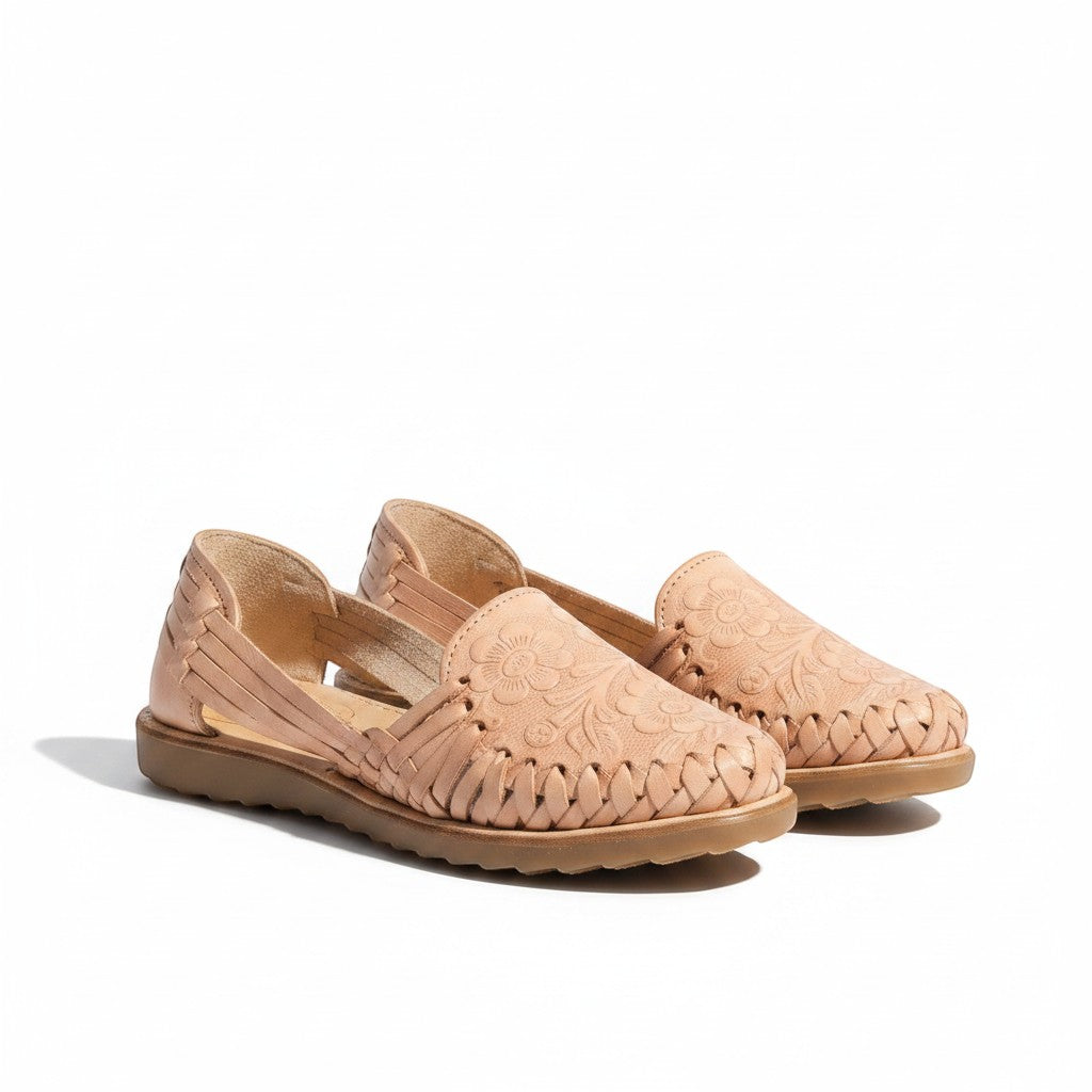 ARTESANALRENVAL tan leather huaraches with woven straps and embossed floral details. Flat sole, open sides.
