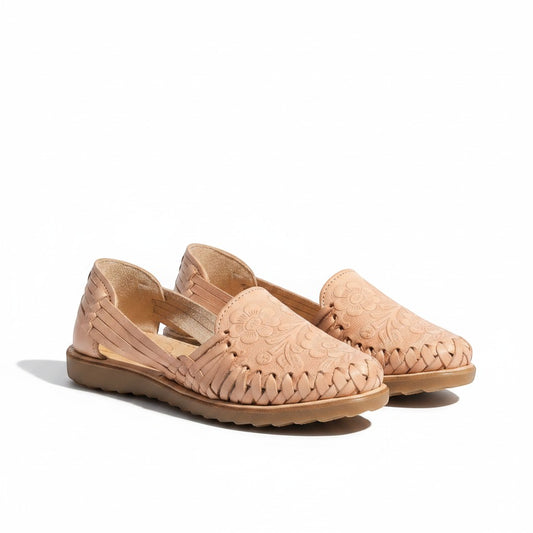 ARTESANALRENVAL tan leather huaraches with woven straps and embossed floral details. Flat sole, open sides.