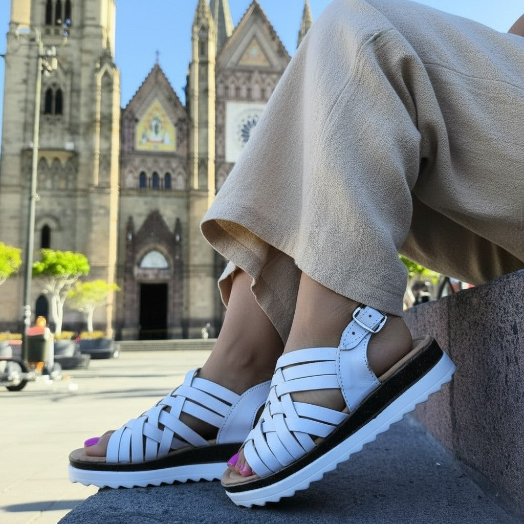 ARTESANALRENVAL white leather huarache sandals with woven straps and buckle closure, on a woman's foot.